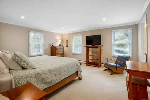 a spacious bedroom with a bed and a flat screen tv