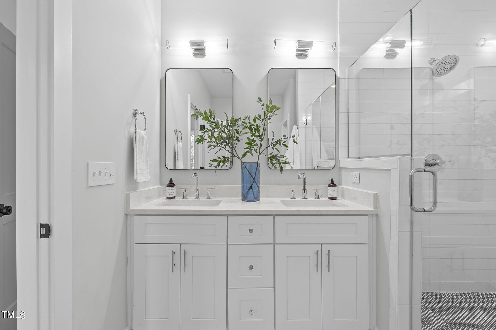 2232 Sheffield Road, Unit 102 Raleigh, NC 27610 - Photo 21 of 32 a bathroom with double vanity sinks and a mirror