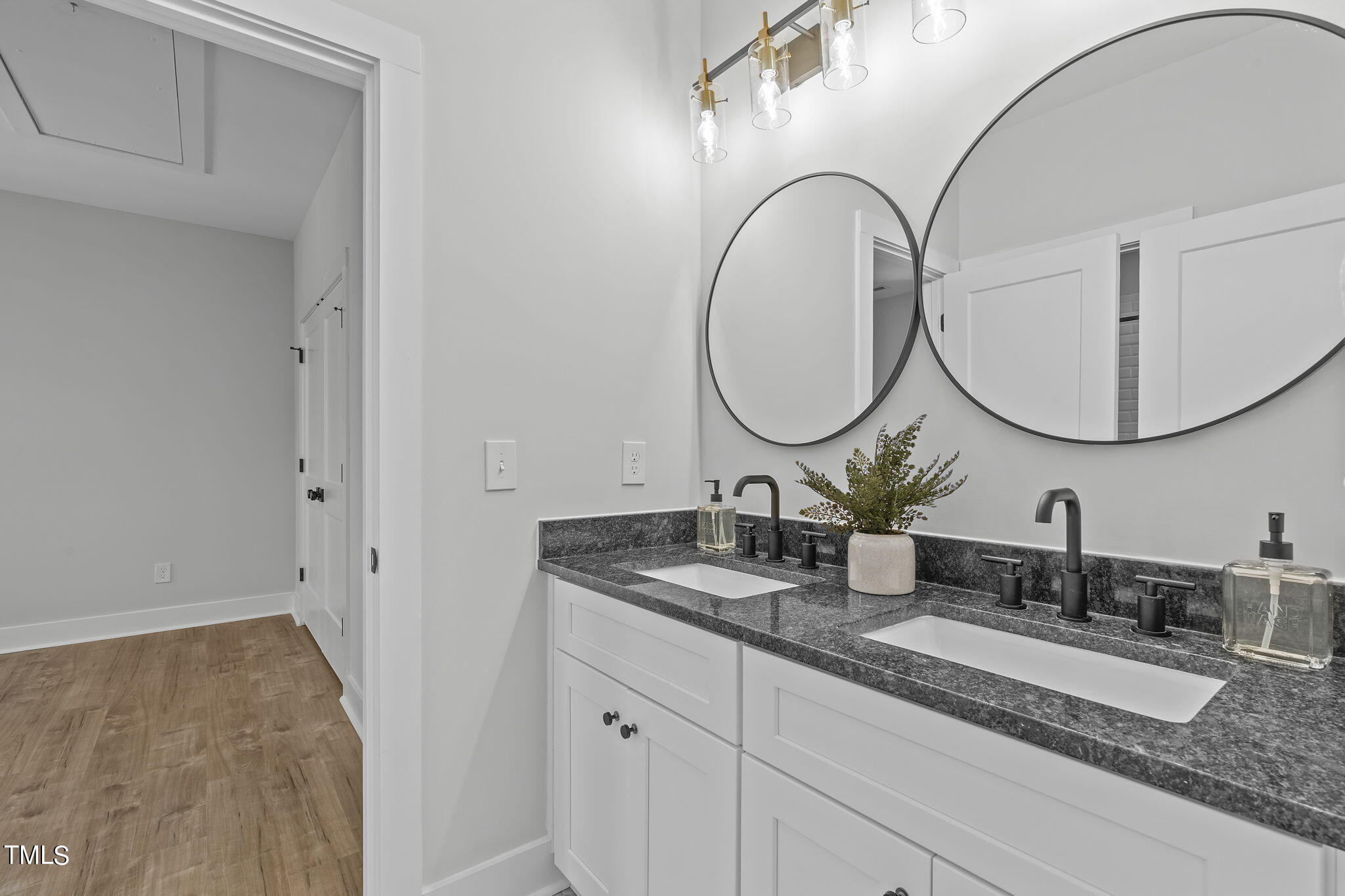 2232 Sheffield Road, Unit 102 Raleigh, NC 27610 - Photo 24 of 32 a bathroom with a granite countertop double vanity sinks and a mirror