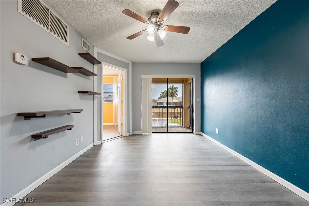 5315 Summerlin Road, Unit 1514 Fort Myers, FL 33919 - Photo 3 of 17 wooden floor in an empty room with a window