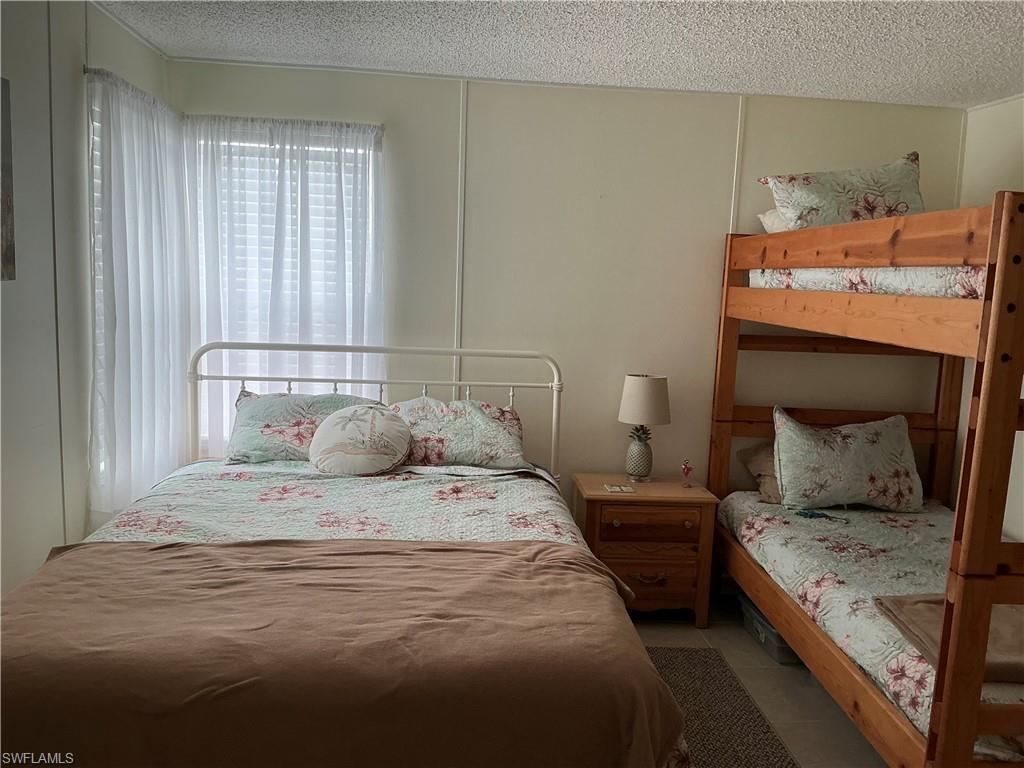 237 Eagle Road, Unit 237 Naples, FL 34114 - Photo 18 of 27 a bedroom with a bed and wooden floor