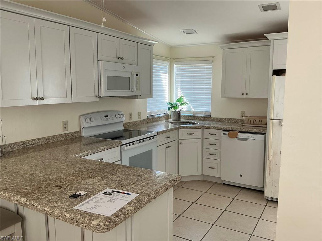 237 Eagle Road, Unit 237 Naples, FL 34114 - Photo 10 of 27 a kitchen with granite countertop a sink stove and cabinets