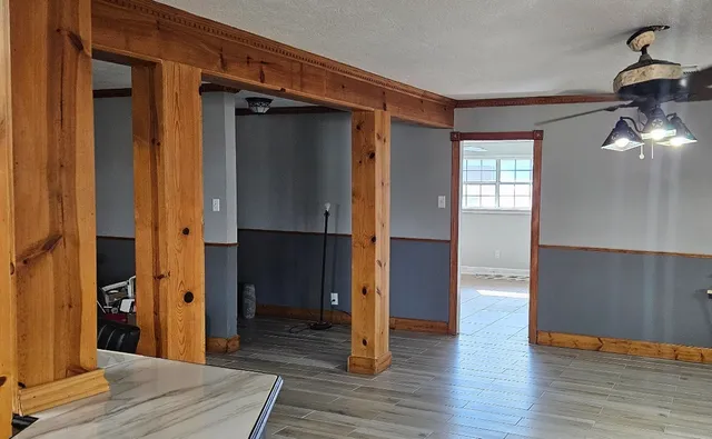 a view of a hallway with wooden floor and staircase