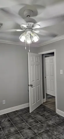 a view of a livingroom with a chandelier fan and wooden floor