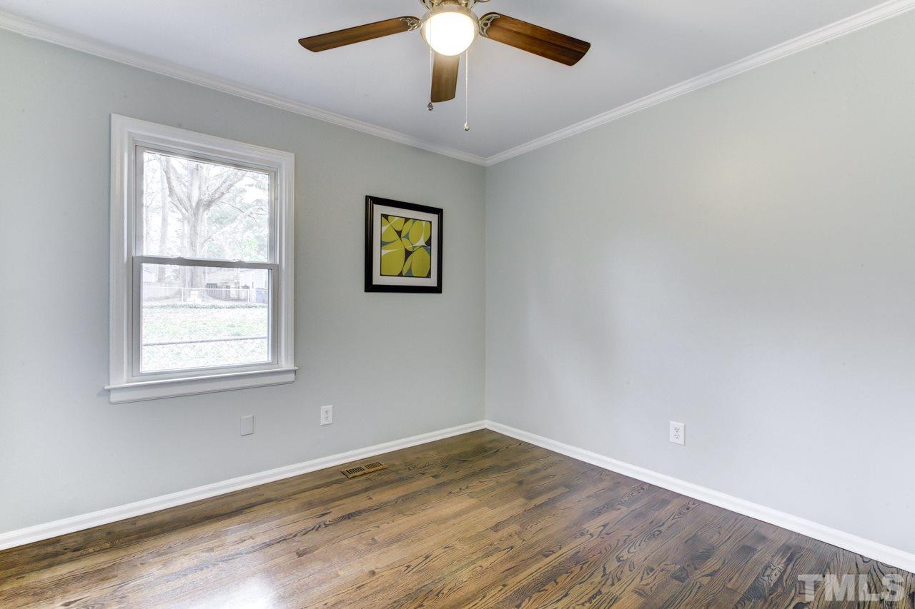 2314 Glascock Street Raleigh, NC 27610 - Photo 18 of 25 a view of an empty room with wooden floor and a window