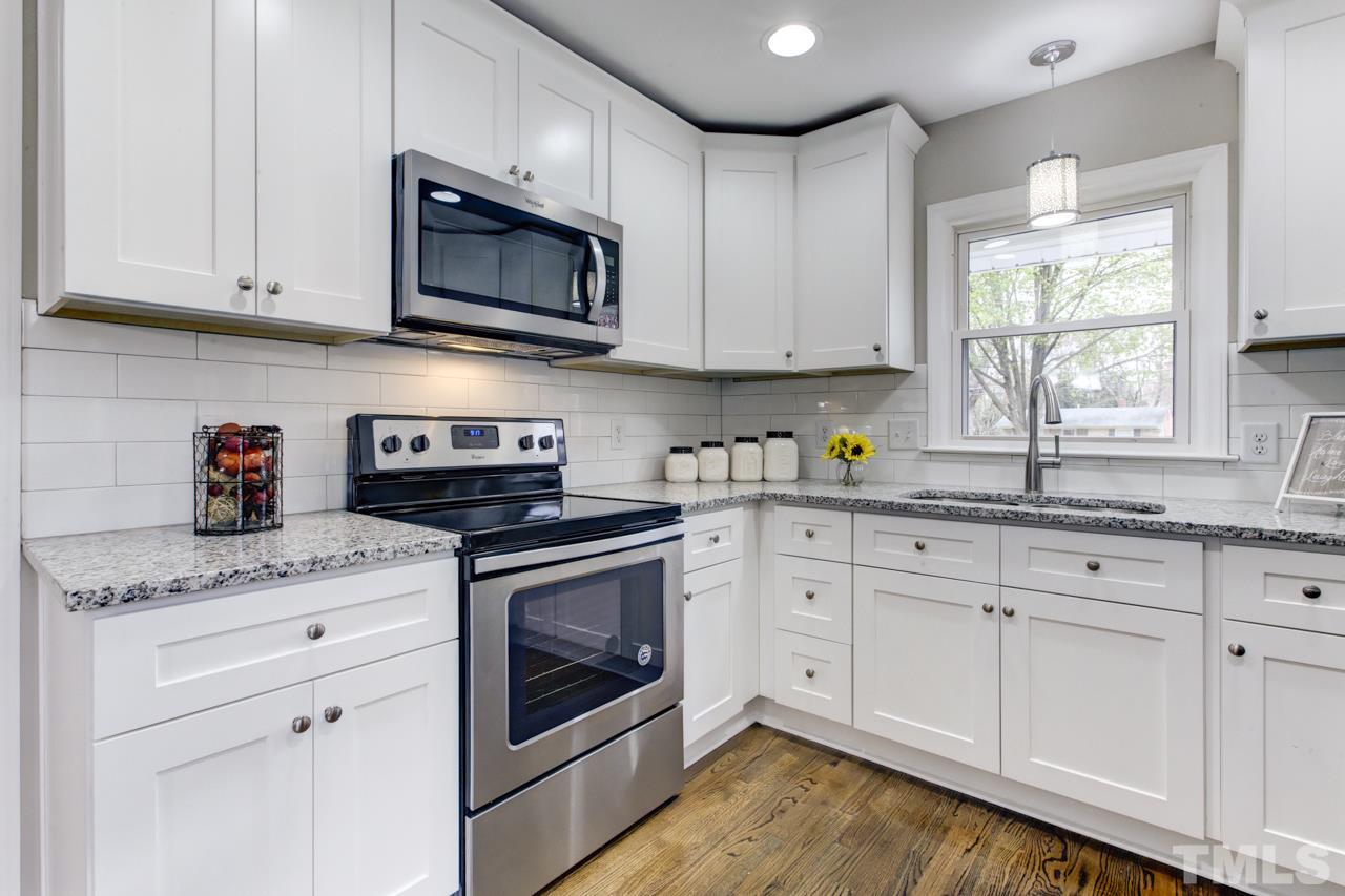 2314 Glascock Street Raleigh, NC 27610 - Photo 9 of 25 a kitchen with granite countertop white cabinets stainless steel appliances and sink