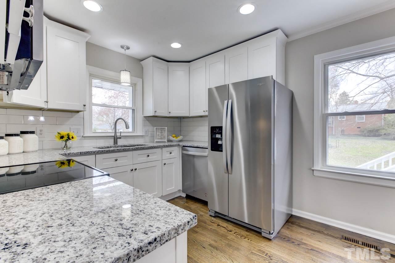 2314 Glascock Street Raleigh, NC 27610 - Photo 10 of 25 a kitchen with a refrigerator a sink a stove a microwave a counter top and cabinets