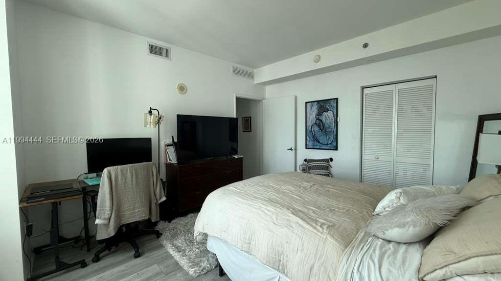 951 Brickell Avenue, Unit 3002 Miami, FL 33131 - Photo 11 of 25 a bedroom with a bed and a television in it
