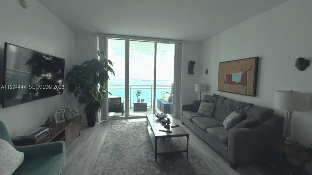 951 Brickell Avenue, Unit 3002 Miami, FL 33131 - Photo 7 of 25 a living room with furniture and a flat screen tv