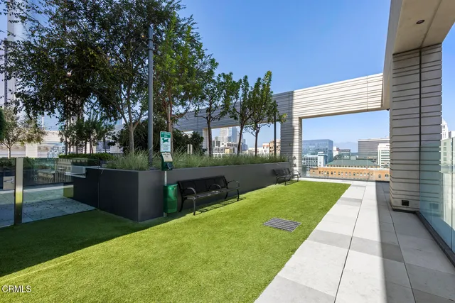 a patio with a table and chairs and potted plants