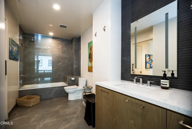 a bathroom with a double vanity sink toilet and a tub