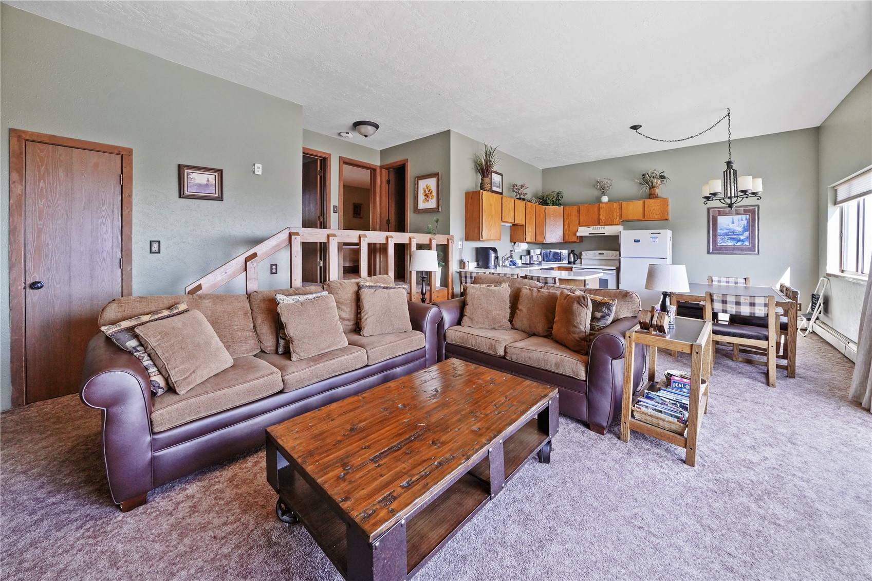9800 Ryan Gulch Road, Unit 108 Silverthorne, CO 80498 - Photo 14 of 33 a living room with furniture a rug and a chandelier