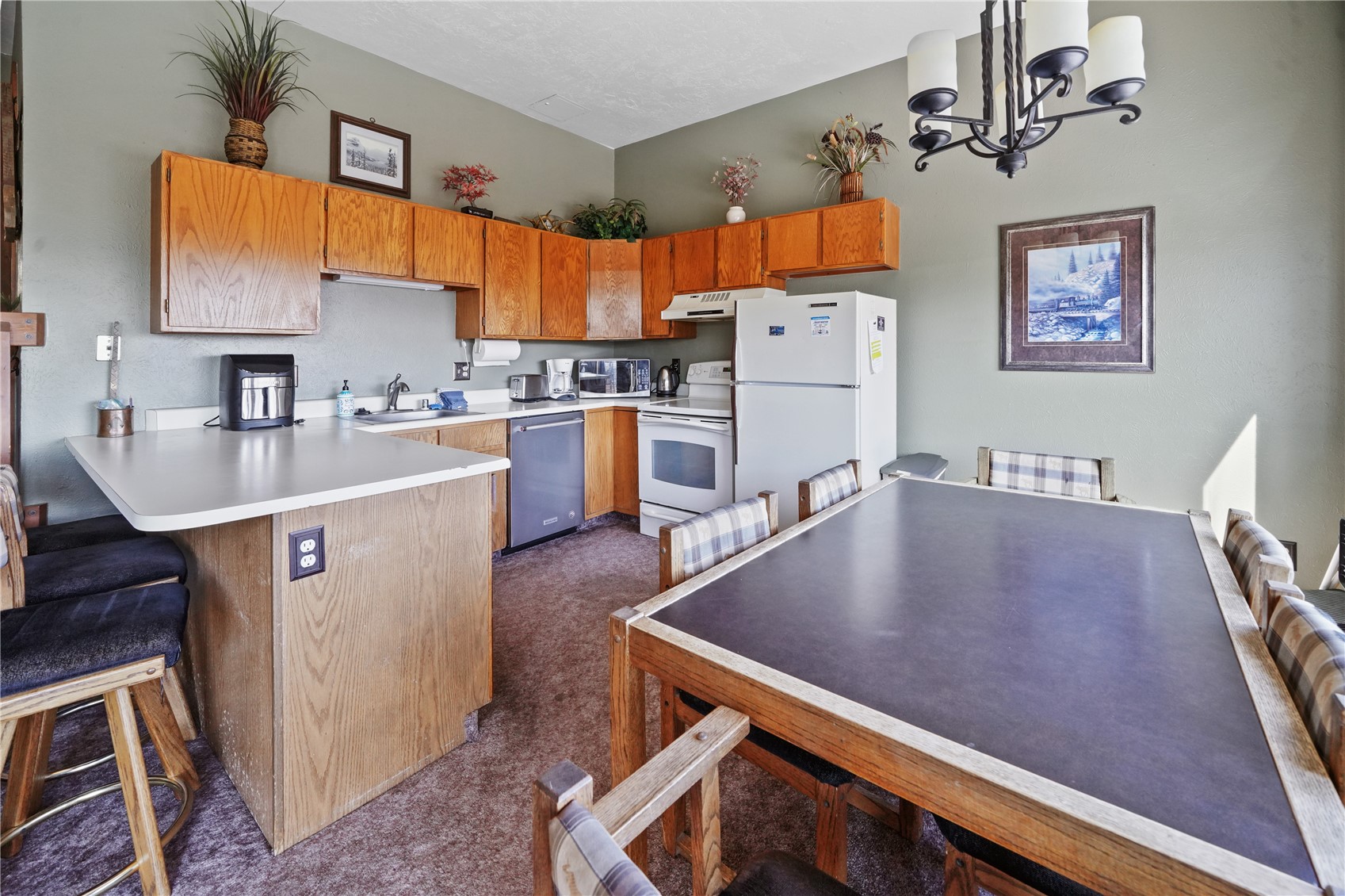 9800 Ryan Gulch Road, Unit 108 Silverthorne, CO 80498 - Photo 20 of 33 a living room with stainless steel appliances kitchen island a table chairs and a sink