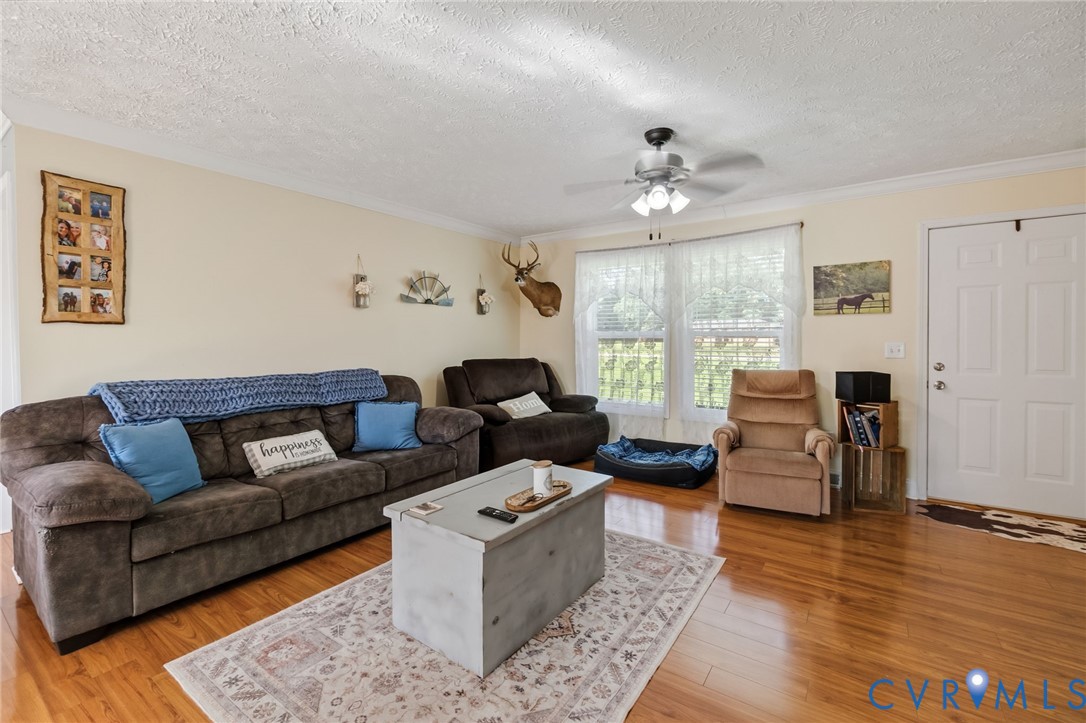 Living area featuring wood-finish flooring, a whit