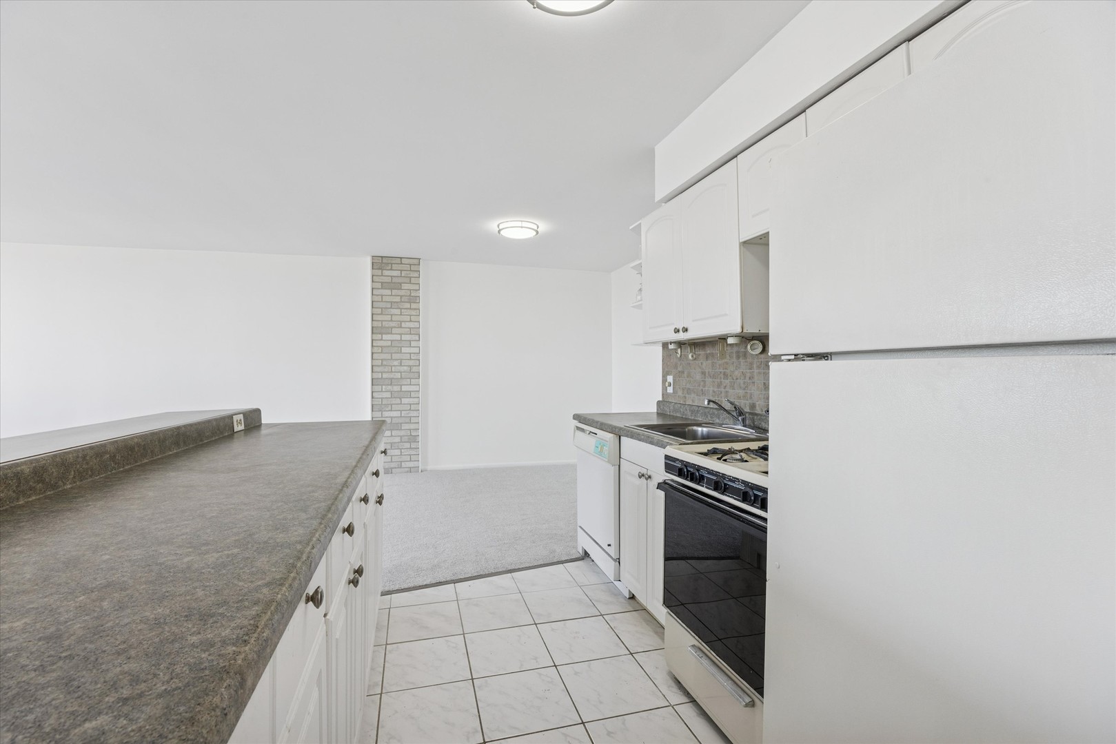 20 North Tower Road, Unit 12L Oak Brook, IL 60523 - Photo 11 of 16 a kitchen with granite countertop a stove and a refrigerator