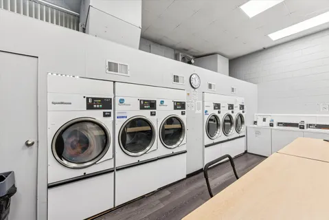a utility room with dryer washer and a view of living room