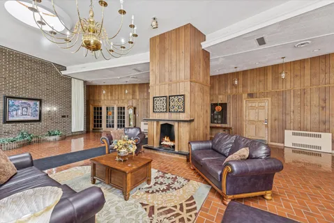 a living room with furniture a fireplace and a chandelier