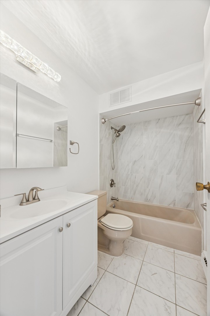 20 North Tower Road, Unit 12L Oak Brook, IL 60523 - Photo 5 of 16 a bathroom with a sink a toilet and shower
