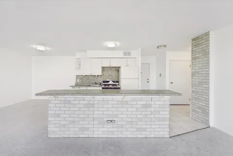 a kitchen with stainless steel appliances granite countertop white cabinets and a granite counter tops
