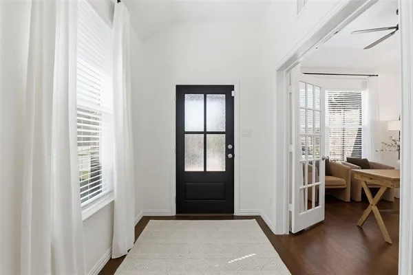 a view of an empty room with a window and wooden floor