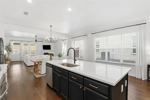 a kitchen with a sink cabinets and wooden floor