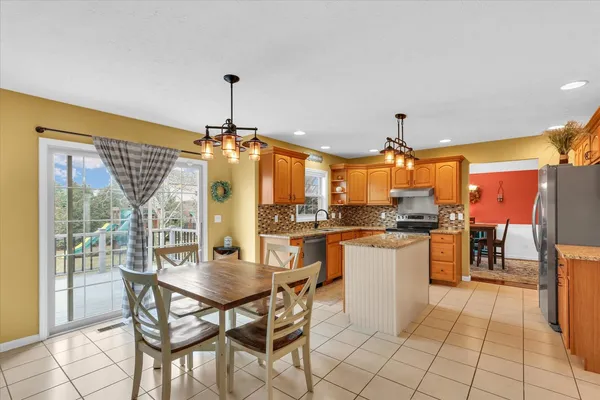 a kitchen with stainless steel appliances granite countertop a stove a refrigerator a oven a sink with island chairs and wooden cabinets