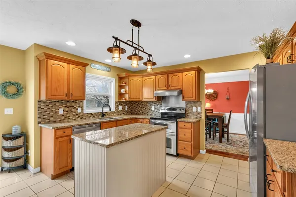 a kitchen with stainless steel appliances granite countertop a sink refrigerator and cabinets