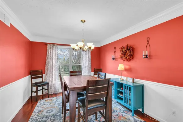 a view of a dining room with furniture a chandelier and wooden floor