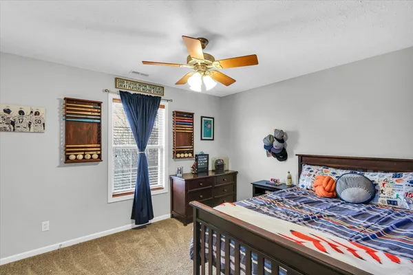 a bedroom with a bed and a fan