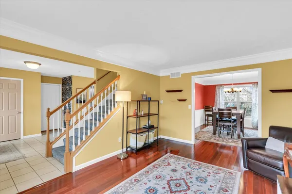 a living room with furniture and a dining table with wooden floor