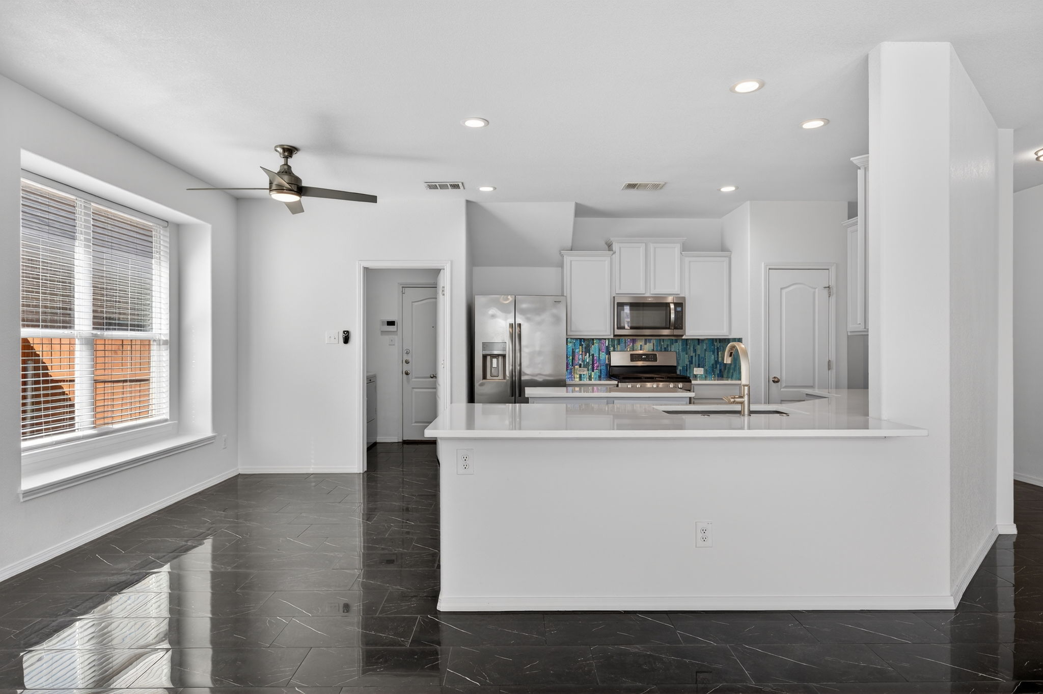 2305 Gavin Trail Pflugerville, TX 78660 - Photo 9 of 40 a view of kitchen with stainless steel appliances granite countertop refrigerator oven a sink dishwasher and white cabinets with wooden floor