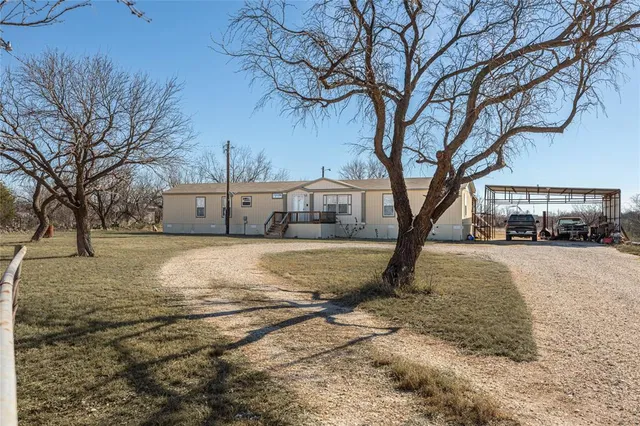 a view of a house with a yard covered in snow