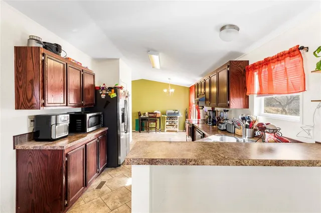 a kitchen with stainless steel appliances granite countertop a sink a stove and a wooden cabinets