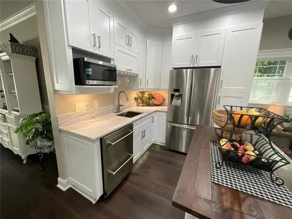 a kitchen with stainless steel appliances a stove a microwave a refrigerator a stove and cabinets