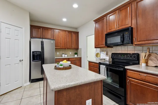 a kitchen with stainless steel appliances granite countertop wooden cabinets a stove top oven a sink and dishwasher
