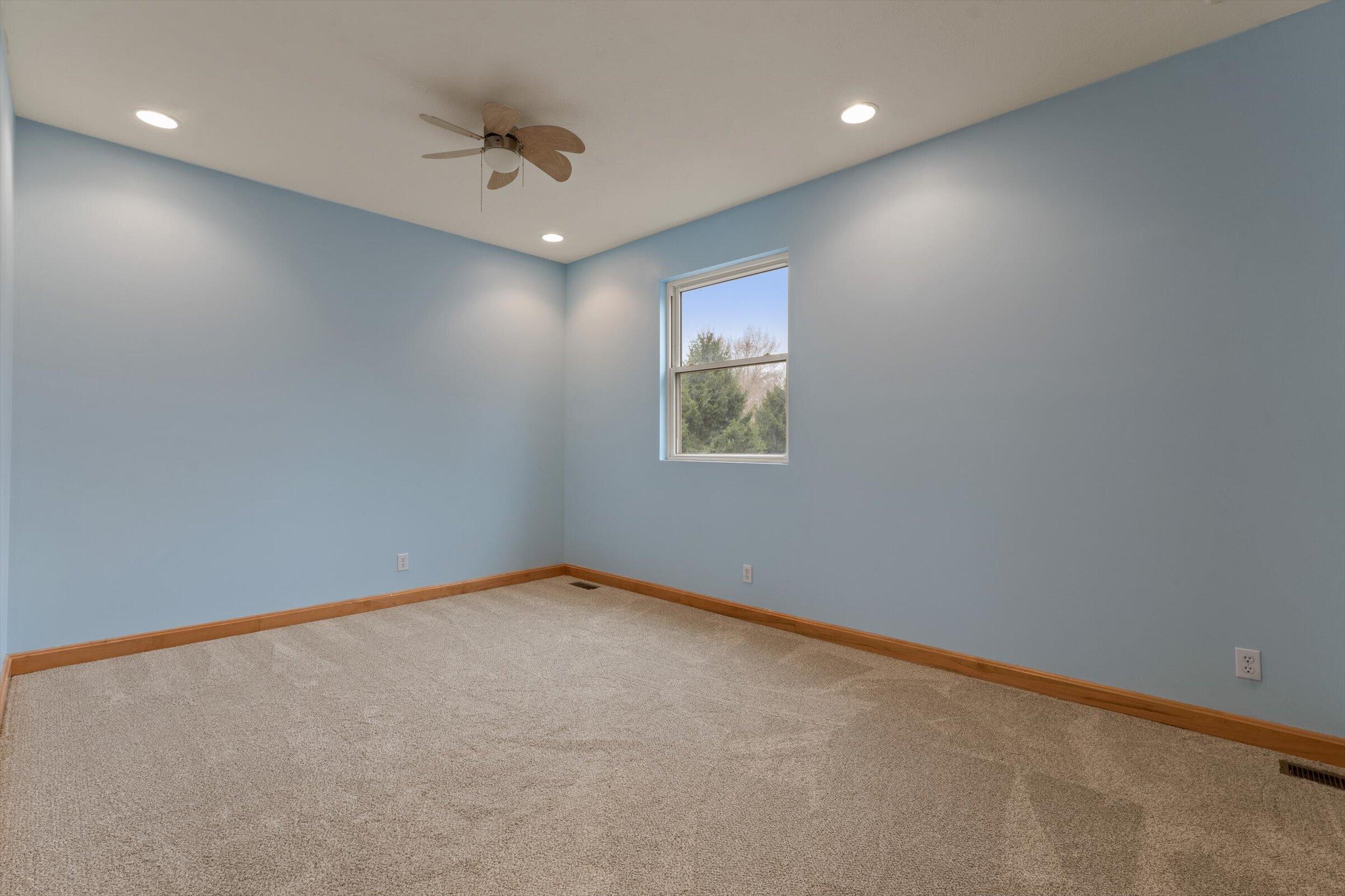 7692 North Emery Road Rolling Prairie, IN 46371 - Photo 37 of 69 an empty room with a ceiling fan and windows