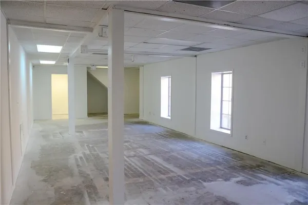 en empty room with windows and ceiling fan