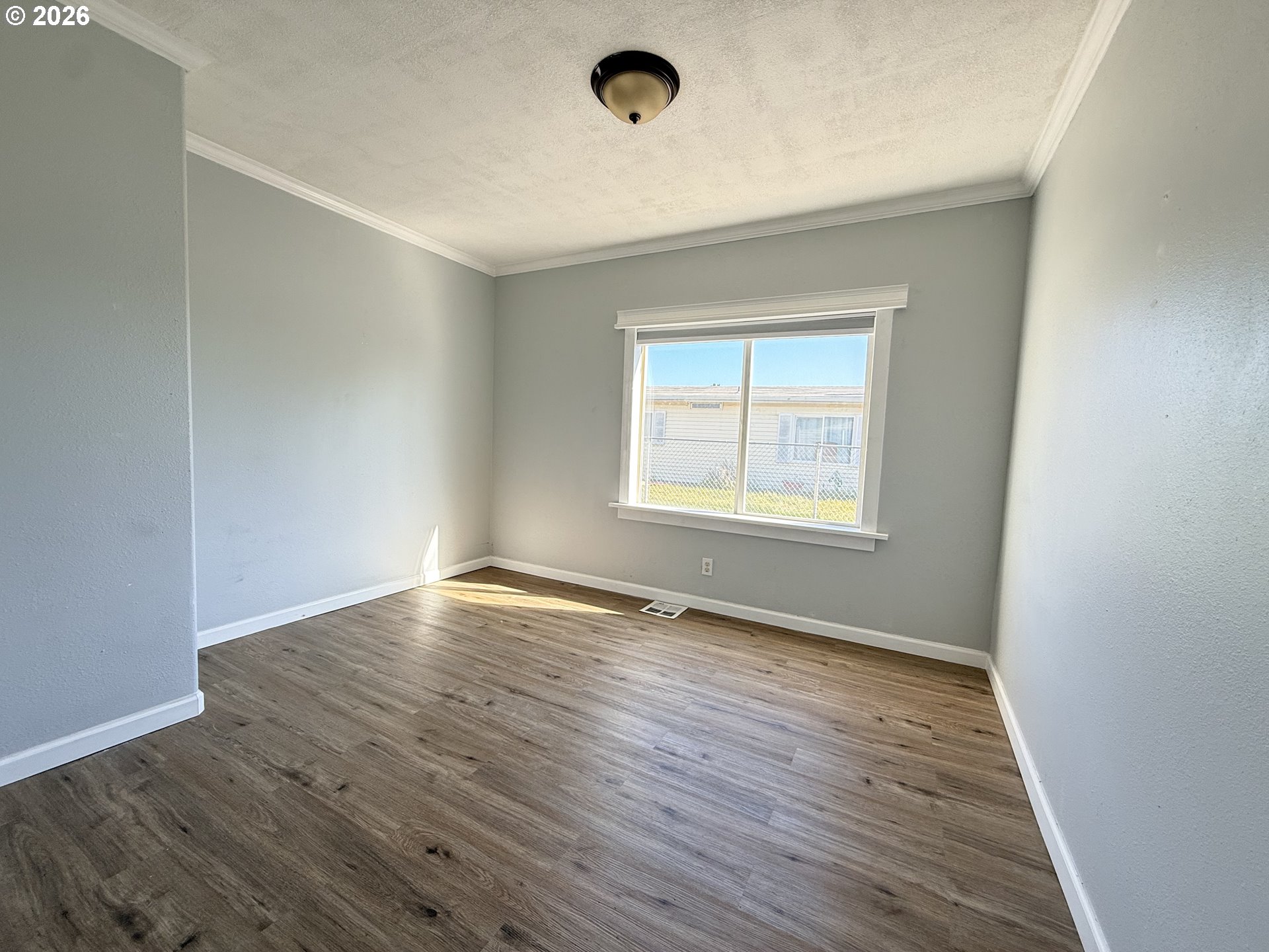1330 West Sunland Avenue Hermiston, OR 97838 - Photo 13 of 23 an empty room with wooden floor and windows