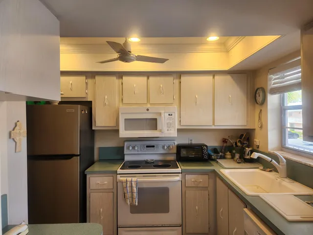 a kitchen with a refrigerator a sink and cabinets