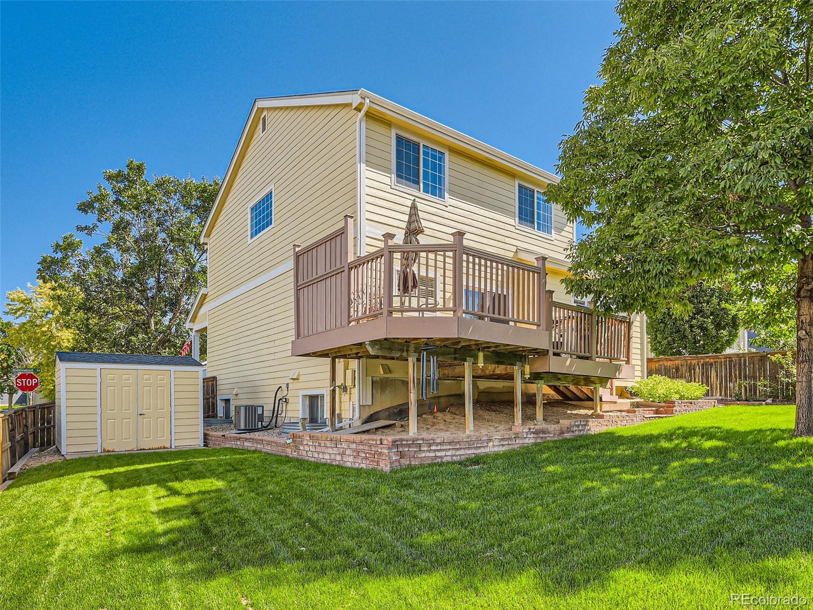 901 Riddlewood Road Highlands Ranch, CO 80129 - Photo 27 of 28 a view of an house with backyard and a tree