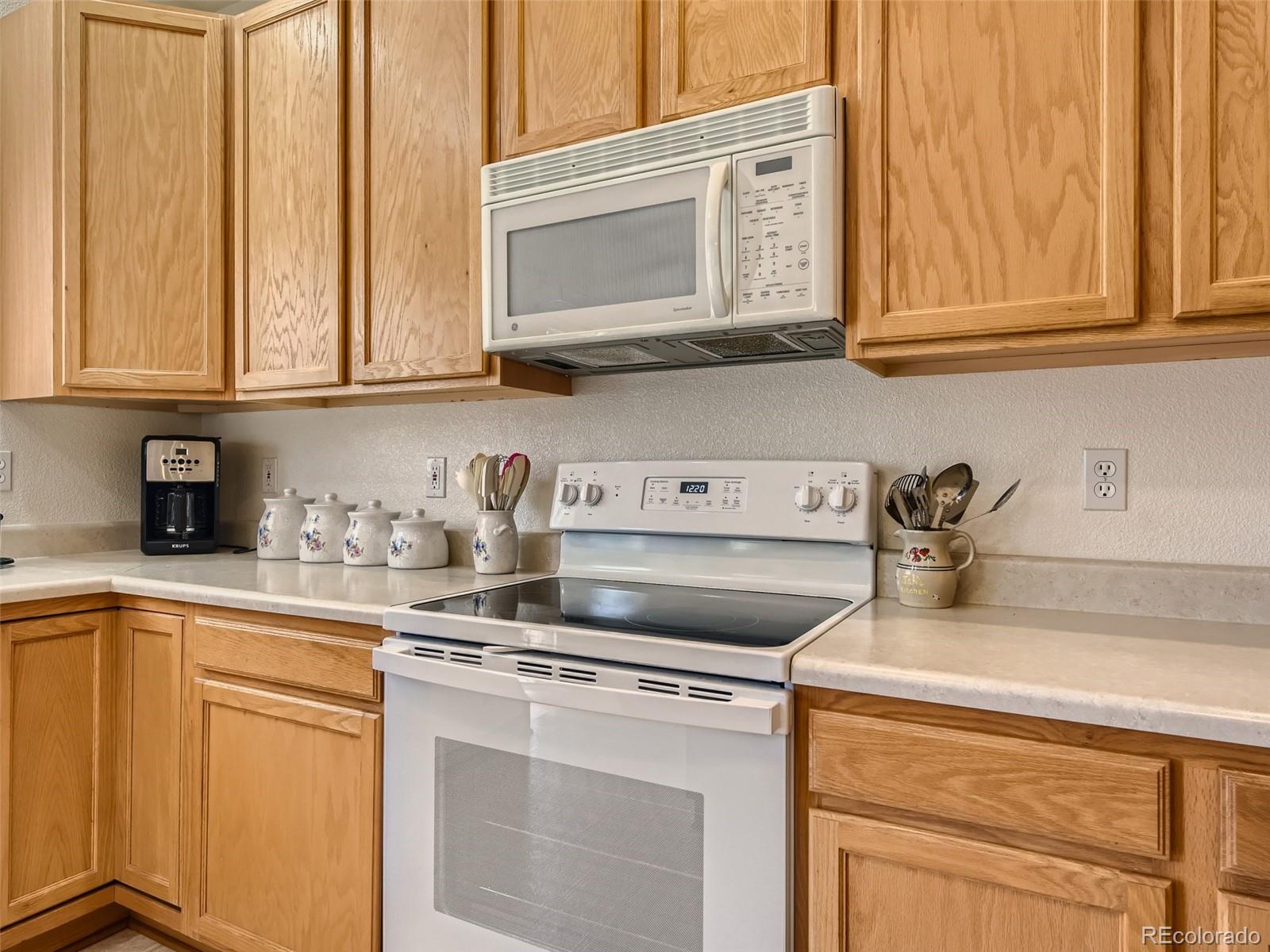 901 Riddlewood Road Highlands Ranch, CO 80129 - Photo 9 of 28 a kitchen with stainless steel appliances granite countertop white cabinets a sink and dishwasher