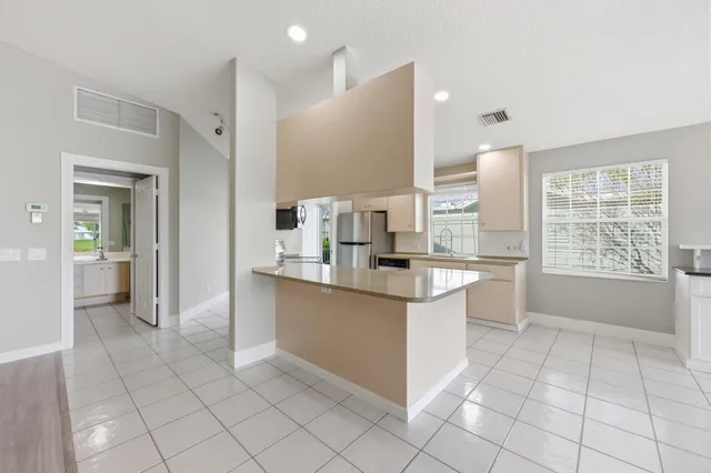 a large kitchen with a window and stainless steel appliances