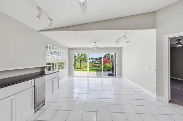 a large white kitchen with a sink and a large window