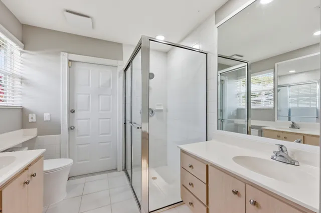 a bathroom with a shower sink vanity and mirror
