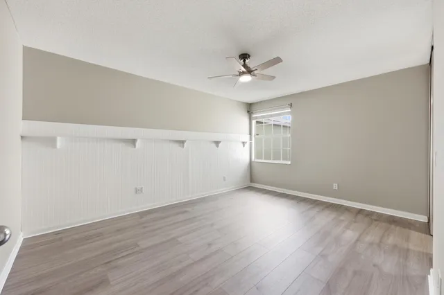 a view of an empty room with wooden floor