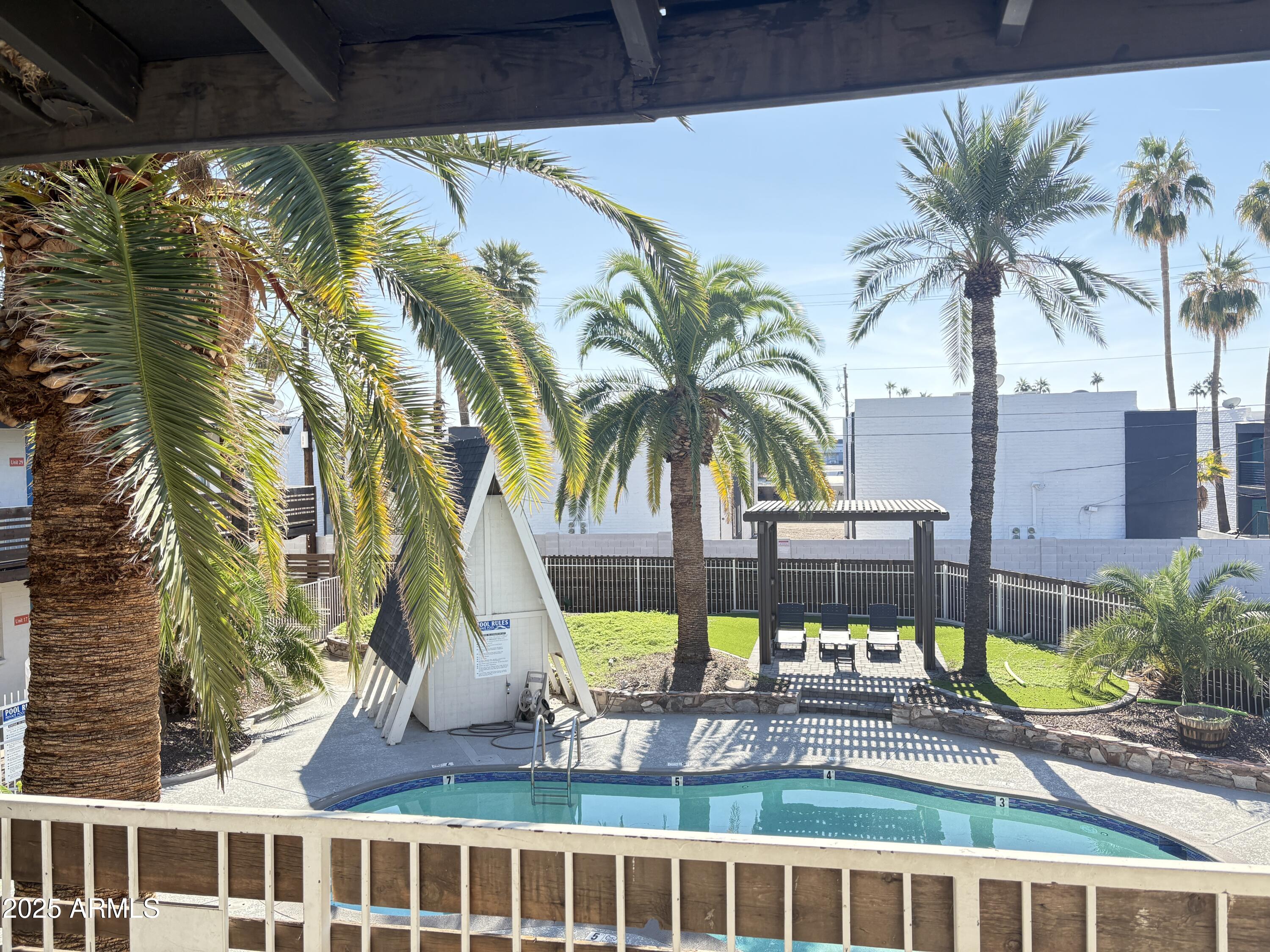 2929 North 38th Street, Unit 1 Phoenix, AZ 85018 - Photo 3 of 6 a view of a swimming pool with a lawn chairs under a large umbrella