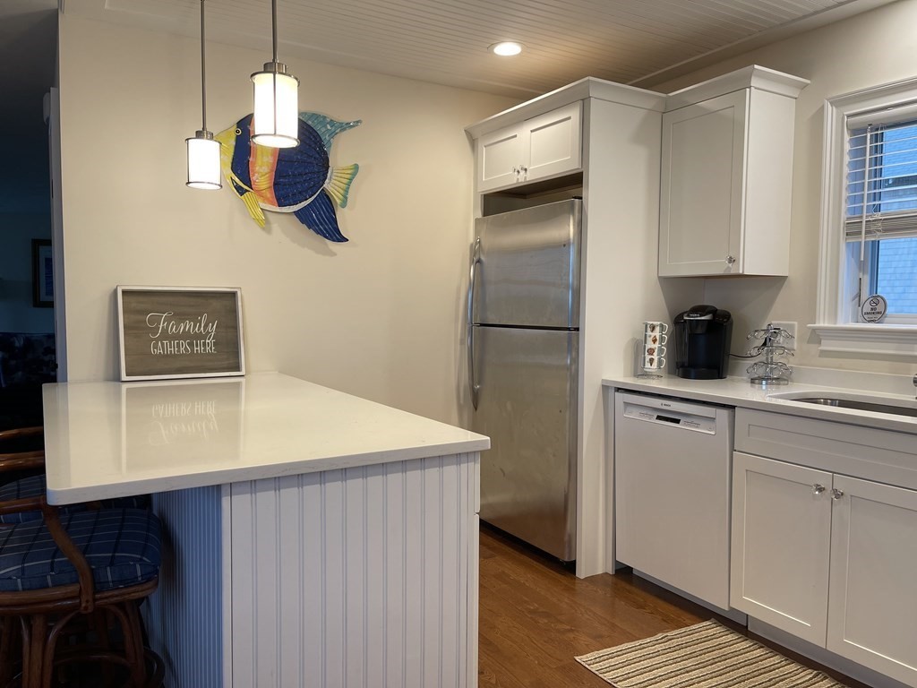 2 Chase Avenue Dennis, MA 02639 - Photo 10 of 24 a kitchen with a refrigerator a stove two sinks and a stove next to a window