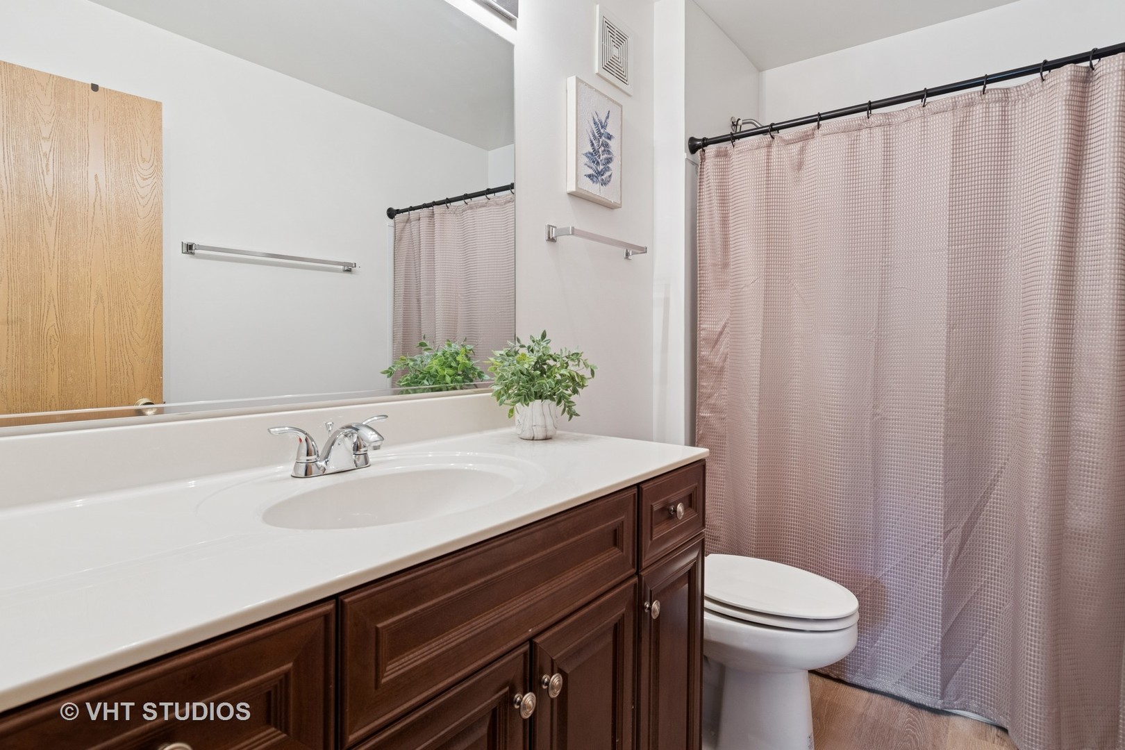 1504 McClure Road, Unit 1504 Aurora, IL 60505 - Photo 16 of 21 a bathroom with a sink a toilet a mirror and shower curtain