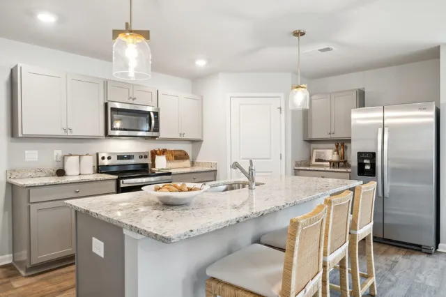 a kitchen with granite countertop a sink stove and refrigerator
