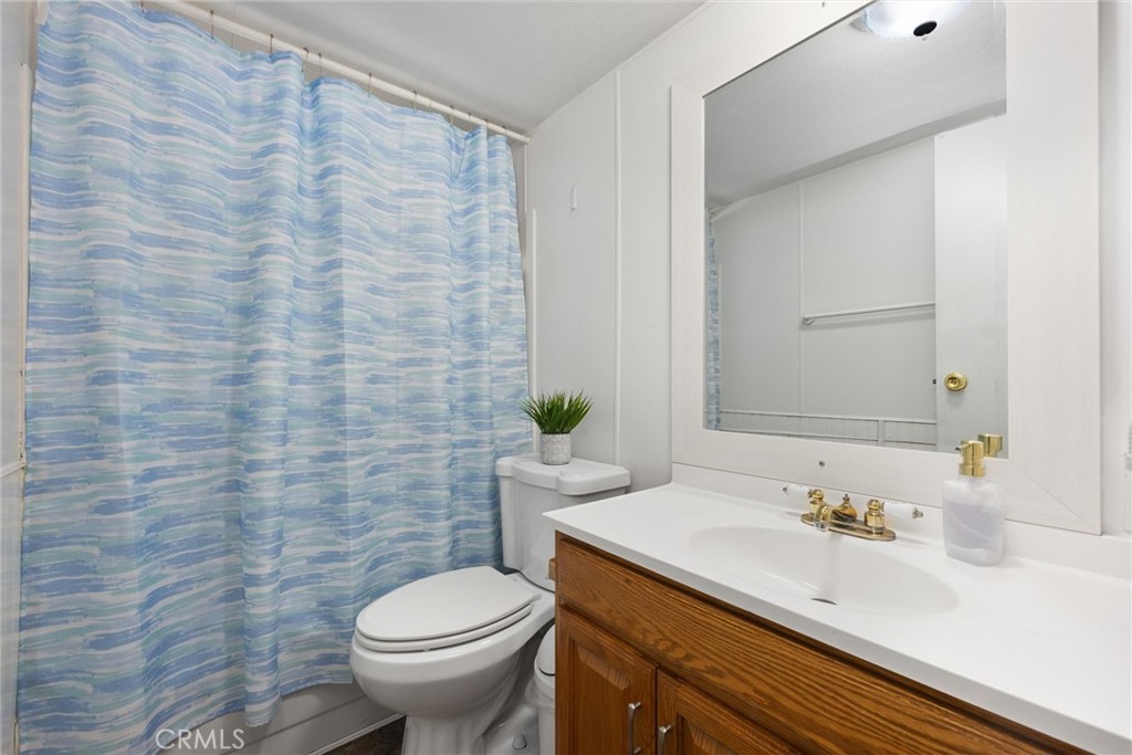 4730 Coronado Street West Bakersfield, CA 93314 - Photo 16 of 29 a bathroom with a granite countertop toilet a sink and a mirror